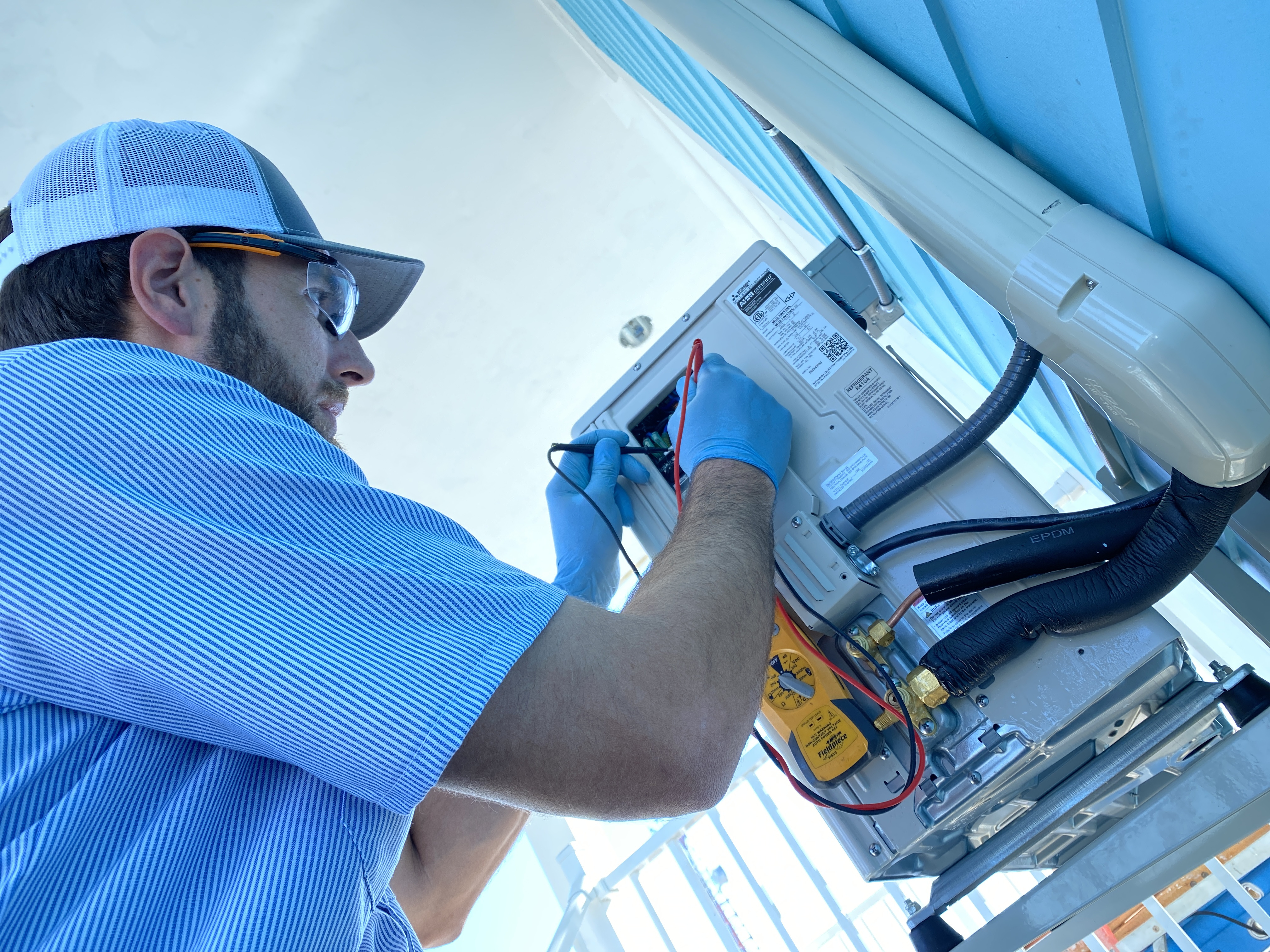 HomePros certified technician inspecting an AC system in Fort Myers Florida